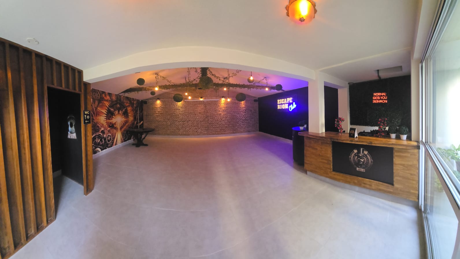 Terraço coberto do Escape Club em Moema, com bar, luzes e neon Escape Room Club